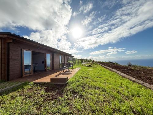 ein Haus auf einem Hügel mit einer Terrasse in der Unterkunft Sunset Eco Shelter 1 in Ponta do Pargo