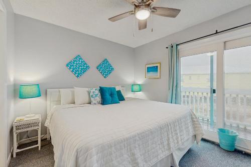 een witte slaapkamer met een bed en een raam bij Fort Morgan Townhomes E7 in Fort Morgan