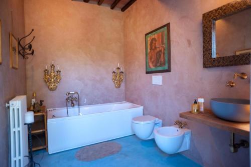 een badkamer met een bad, een toilet en een wastafel bij Villa Marinsky Pietrasanta in Pietrasanta