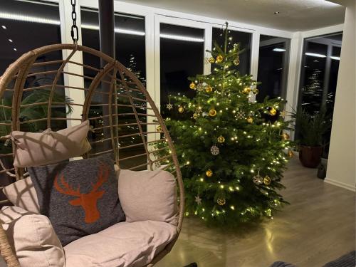 een kerstboom in een woonkamer naast een stoel bij RhönLoft in Ostheim