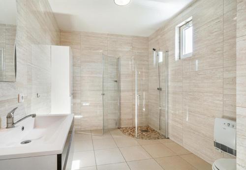 een badkamer met een douche en een wastafel bij Camping 2000 - Vakantiewoning XL in Osečná