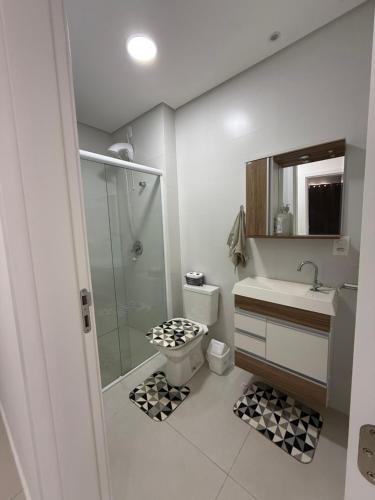 een badkamer met een douche, een toilet en een wastafel bij Apartamento Elegante 2 Quartos in Balneário Camboriú