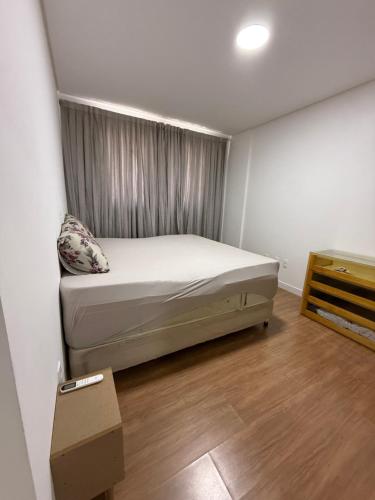 een kleine slaapkamer met een bed en een dressoir bij Apartamento Elegante 2 Quartos in Balneário Camboriú