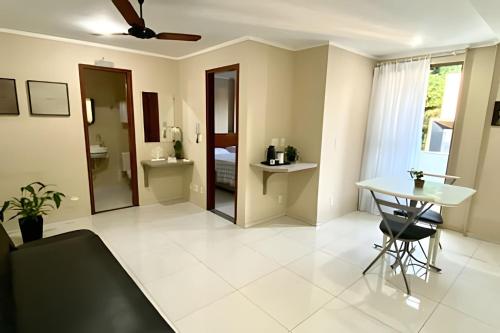 a living room with a table and a mirror at Classe A in Viçosa