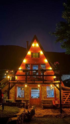 a large wooden house with lights on it at night at Villa Alpi in Nižepole
