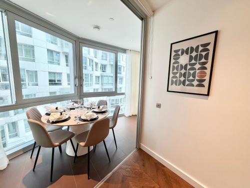 a dining room with a table and chairs at Battersea Power Apartments in London