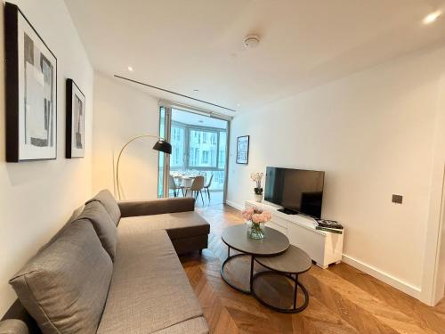 a living room with a couch and a table at Battersea Power Apartments in London