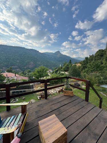 a wooden deck with a bench and a view of mountains at Villa Alpi in Nižepole