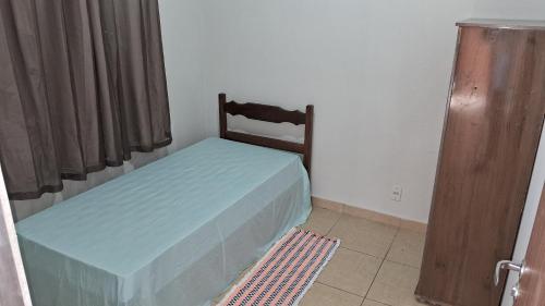 een slaapkamer met een bed met een houten hoofdeinde bij Pousada Central in Montes Claros