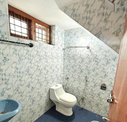 a bathroom with a toilet and a sink at White Haven in Angamaly