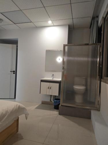 ein Badezimmer mit Waschbecken und Toilette in einem Zimmer in der Unterkunft Tangmu Hostel in Kunming