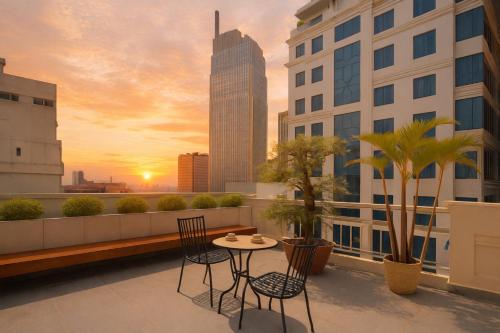 a balcony with a table and chairs on a building at White Lotus Hotel Saigon in Ho Chi Minh City