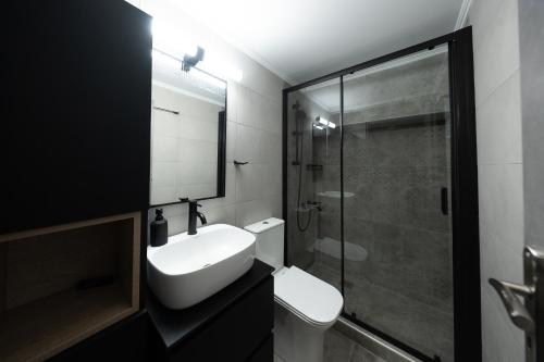 a bathroom with a toilet and a sink and a shower at Oniro Living - Skra 10 in Mytilene