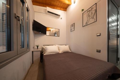 a small room with a bed and a tv at Oniro Living - Skra 10 in Mytilene