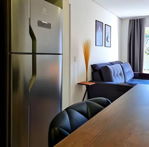 a kitchen with a refrigerator and a table at Apartamento Loft Gramado in Gramado