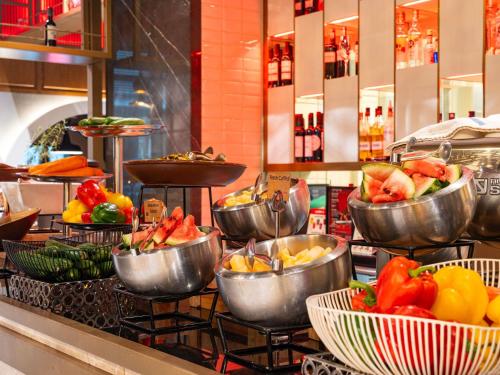 a buffet line with bowls of fruit and vegetables at ibis Dubai One Central in Dubai