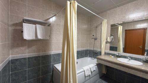 乌尔根奇Khorezm Palace Hotel的带浴缸、马桶和水槽的浴室