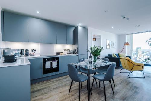 een keuken en woonkamer met een tafel en stoelen bij City View Apartment with Pool in Manchester