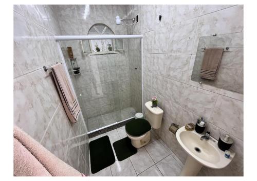 un bagno con doccia, WC e lavandino di Urban Executive Residence a Itaguaí