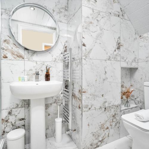 a white bathroom with a sink and a mirror at Four Bed House - Sleeps 7 - Garden - Parking - Smart TV 6COK in Birmingham