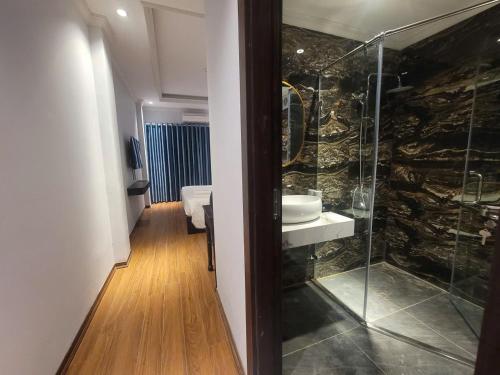 a bathroom with a glass shower and a sink at Maya Central Hotel & Spa in Hanoi