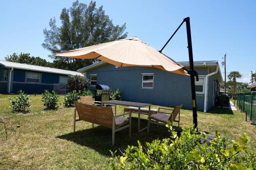 een tafel en stoelen onder een paraplu in een tuin bij Villa On The Ocean in Fort Pierce