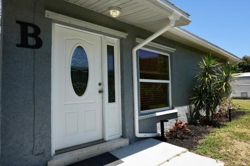 een huis met een witte deur met een raam bij Villa On The Ocean in Fort Pierce