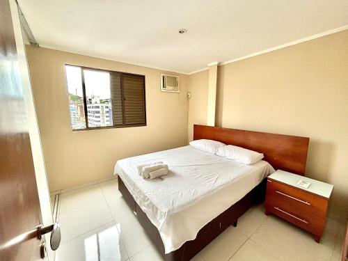 una piccola camera da letto con un letto e una finestra di Classe A a Viçosa