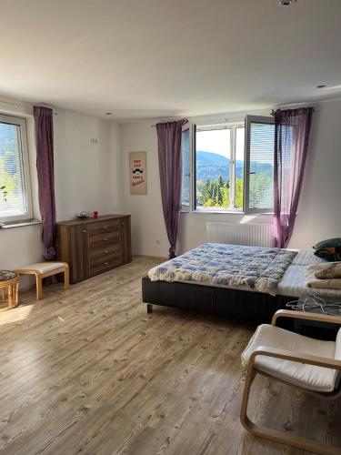 a bedroom with a bed and a large window at Ferienwohnung am Faaker See in Latschach