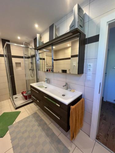 a bathroom with a sink and a large mirror at Ferienwohnung am Faaker See in Latschach