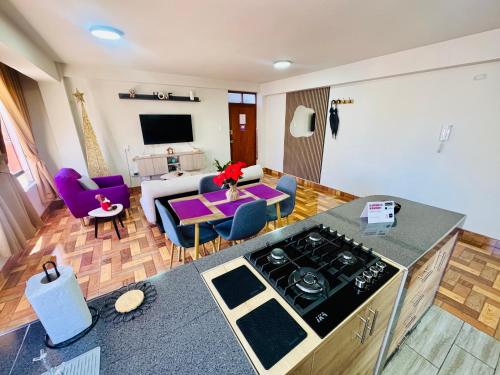 een keuken en een woonkamer met paarse stoelen en een tafel bij Solena Apartamentos Tacna in Tacna
