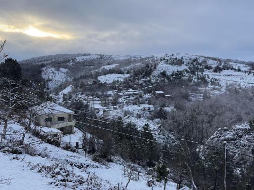 a view of a snow covered mountain with a town at O cantinho do Avô Alberto