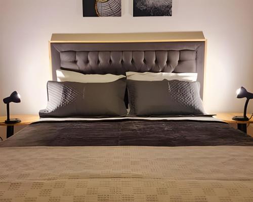 a bedroom with a large bed with two pillows at Apartamento Major Nicoletti in Gramado