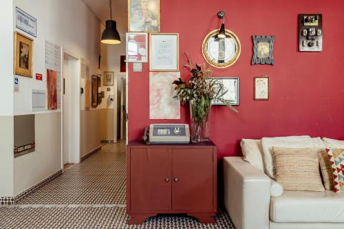 a living room with a white couch and a red wall at Labor Alliance Residence by LovelyStay in Lisbon