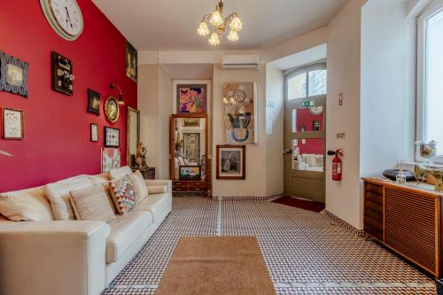 a living room with a white couch and a red wall at Labor Alliance Residence by LovelyStay in Lisbon