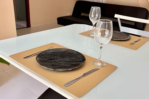 a white table with two glasses and plates on it at Classe A in Viçosa