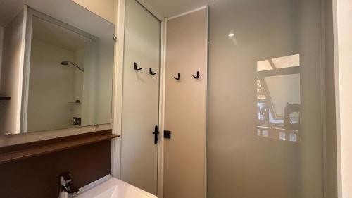 a bathroom with a white cabinet and a mirror at Camping Les Pêcheurs - Maeva in Roquebrune-sur-Argens