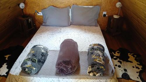 a bed with a pair of shoes on it at Chalé romântico com hidro, lareira e churrasqueira na Serra in Serra Negra