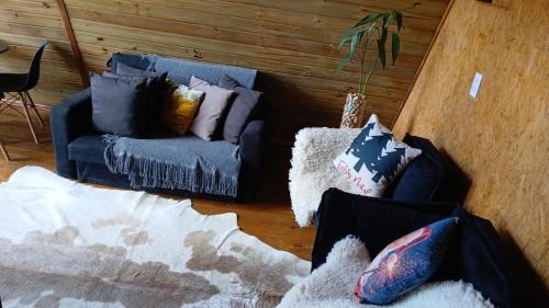 a living room with a couch and pillows at Chalé romântico com hidro, lareira e churrasqueira na Serra in Serra Negra