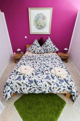 a bedroom with a bed with a purple wall at Vollumen Business-Juniorsuite in Redwitz an der Rodach
