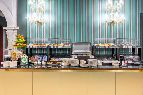 een buffet met gebak en etenswaren die tentoongesteld staan. bij Hotel Villa Viridia in Venetië