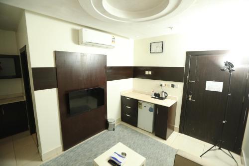 een kamer met een badkamer met een wastafel en een televisie bij Lamar Al Bawadi Hotel in Jeddah