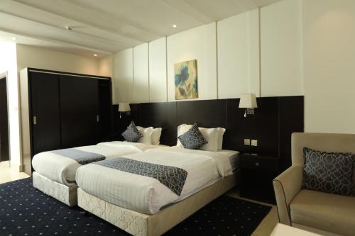 een slaapkamer met een groot bed en een stoel bij Lamar Al Bawadi Hotel in Jeddah