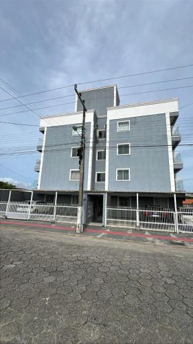 un edificio con una recinzione bianca di fronte di Aurora Boreal a Tijucas