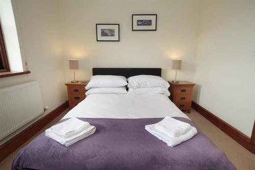 een slaapkamer met een groot bed met witte lakens en kussens bij 4 Bed in Gower oc-hh151 in Llangennith