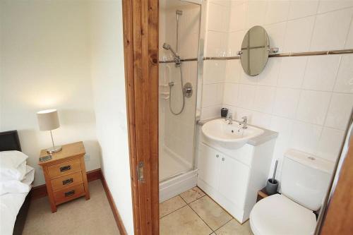 een badkamer met een douche, een toilet en een wastafel bij 4 Bed in Gower oc-hh151 in Llangennith