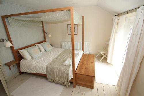 a bedroom with a canopy bed and a wooden table at 2 Bed in Mumbles oc-hh133 in The Mumbles