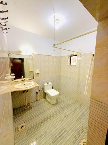 a bathroom with a sink and a toilet and a mirror at Karachi Family Guest House in Karachi