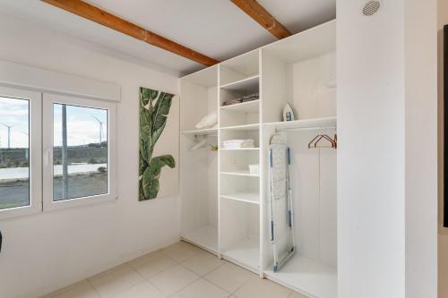 Cette chambre dispose d'étagères blanches et d'une fenêtre. dans l'établissement El Doctoral, à Vecindario