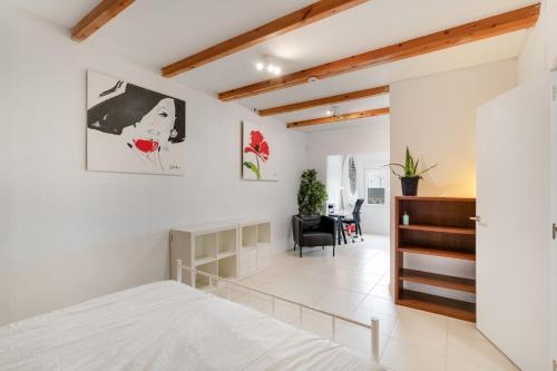 - une chambre avec des murs blancs, un lit et un bureau dans l'établissement El Doctoral, à Vecindario